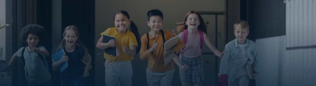 Enfants souriants à l'école illustrant la protection grâce à l'assurance scolaire
